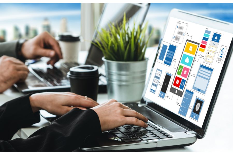 Laptop showing app design and wireframes.
