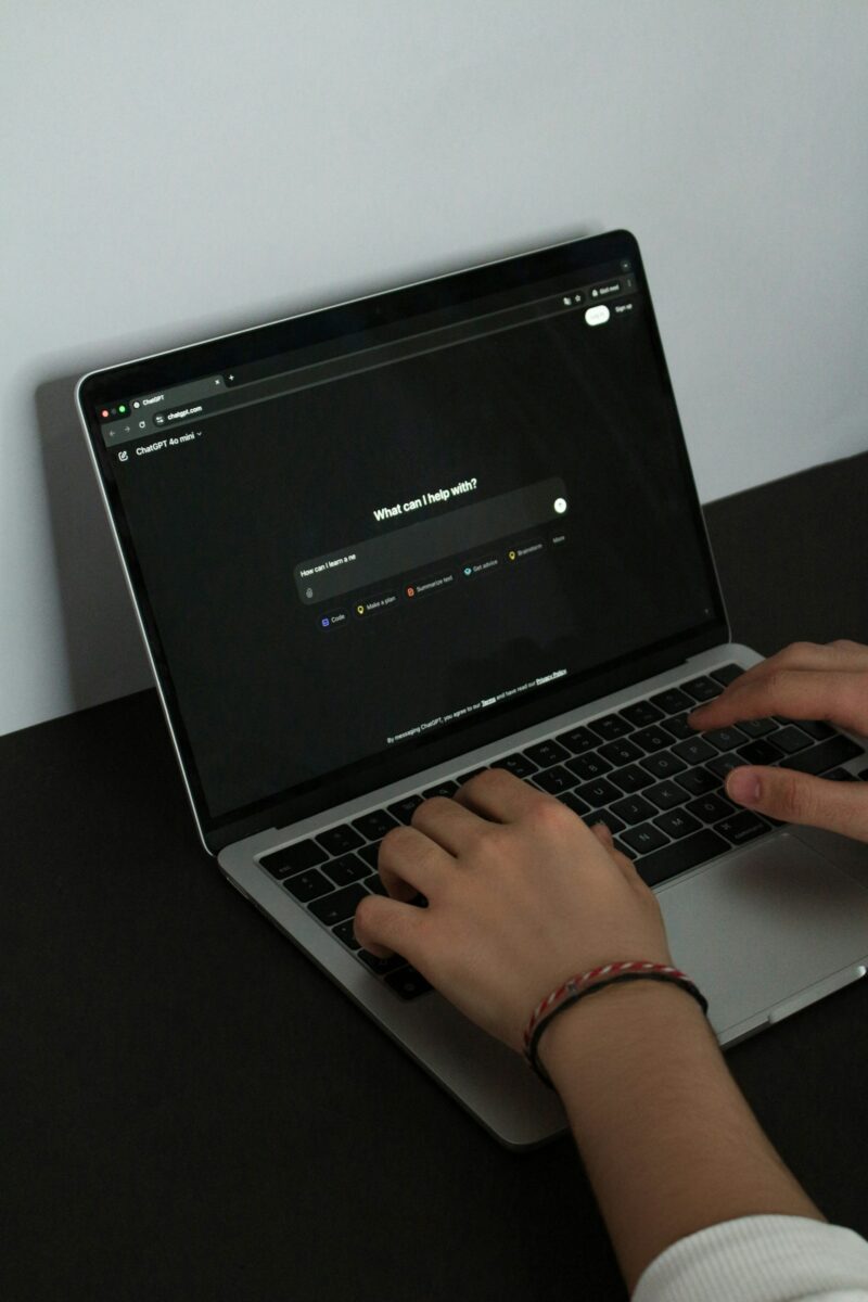 Person typing on laptop with ChatGPT interface